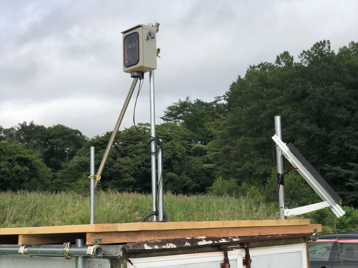 長期タイムラプス撮影ケースから伸びる電源とソーラーパネルなどの装置